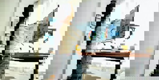 Woman at standing desk holding her neck in pain