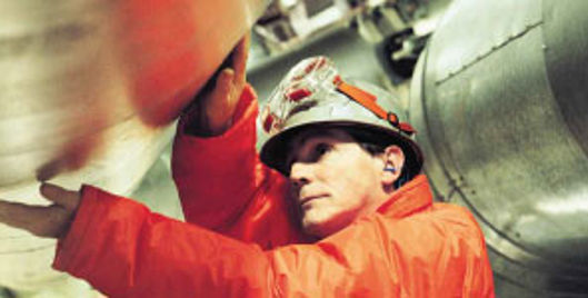 Man in high vis and PPE inspecting equipment