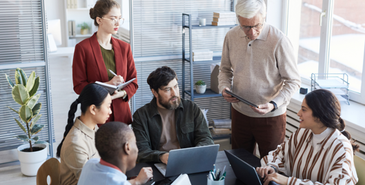 A diverse group of six people working together in a meeting room in an office