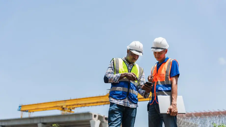 Workers reviewing information on a clipboard in a warehouse