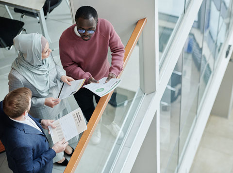 Colleagues discussing documents together in a modern workplace.