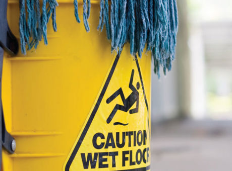 Blue mop in a yellow bucket labelled "Caution wet floor"