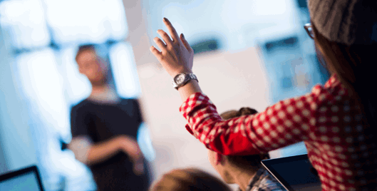 Woman with hand raised asking a question