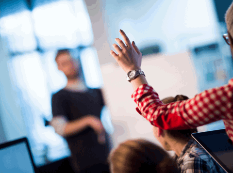 Woman with hand raised asking a question
