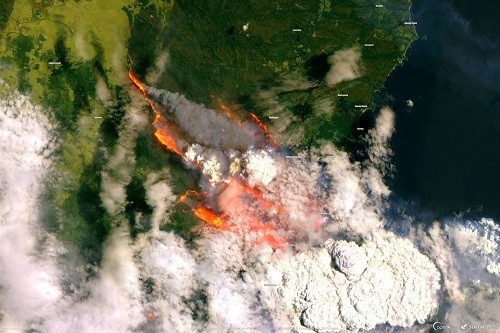 A satellite image of Batemans Bay, Australia, showing smoke and fire from wild bushfires in December 2019