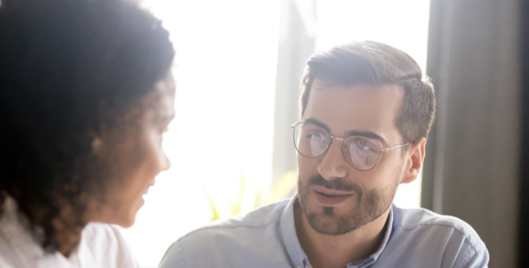 Man and woman having a conversation in front of a brightly lit window
