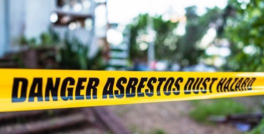 Black and yellow warning tape that says "danger asbestos dust hazard"