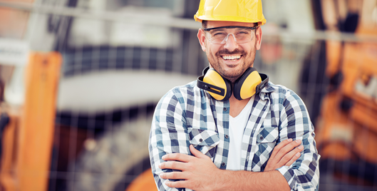 British Safety Council Membership - Man with hard hat, protective eyewear  and ear defenders around his neck smiling
