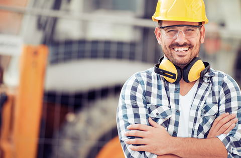British Safety Council Membership - Man with hard hat, protective eyewear  and ear defenders around his neck smiling