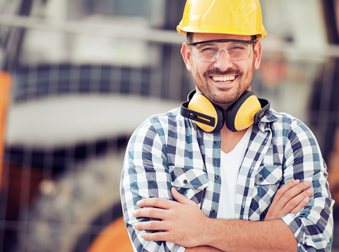 British Safety Council Membership - Man with hard hat, protective eyewear  and ear defenders around his neck smiling