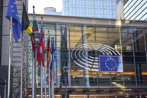 EU flags on glass walls of Berlaymont, that houses the headquarters of the European Commission, the executive of the European Union