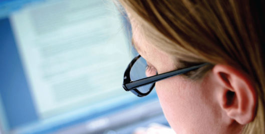 Woman wearing glasses working on a computer