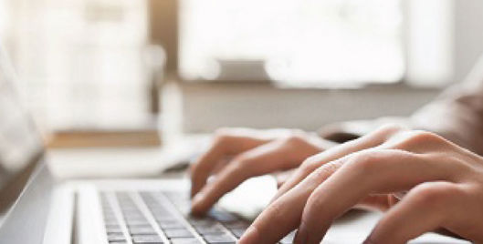 Person typing on a laptop keyboard with both hands