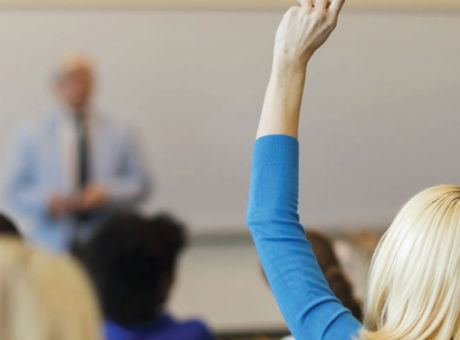 Woman with hand up in classroom