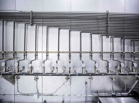 Industrial water system with steel pipes and pressure gauges.