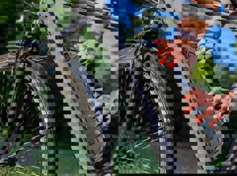 Person putting lithium ion battery on electric bike in a park