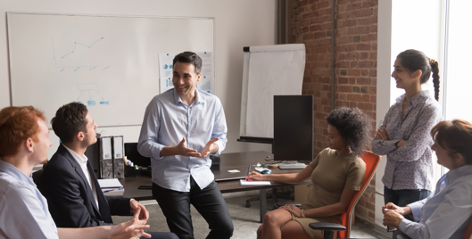 Group of people sat around in an office having a positive discussion