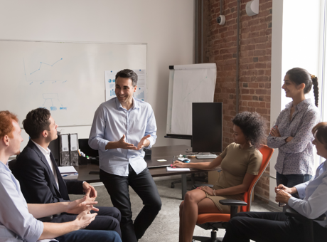 Group of people sat around in an office having a positive discussion