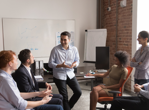 Group of people sat around in an office having a positive discussion