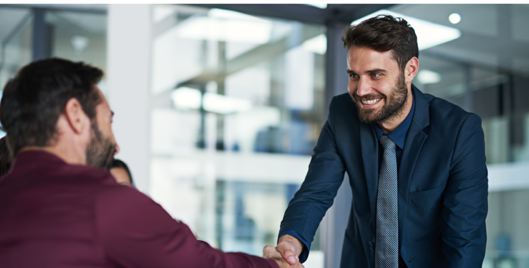 Smiling man shaking another mans hand in an office