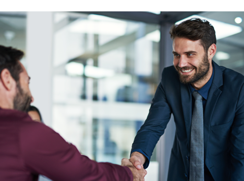 Smiling man shaking another mans hand in an office